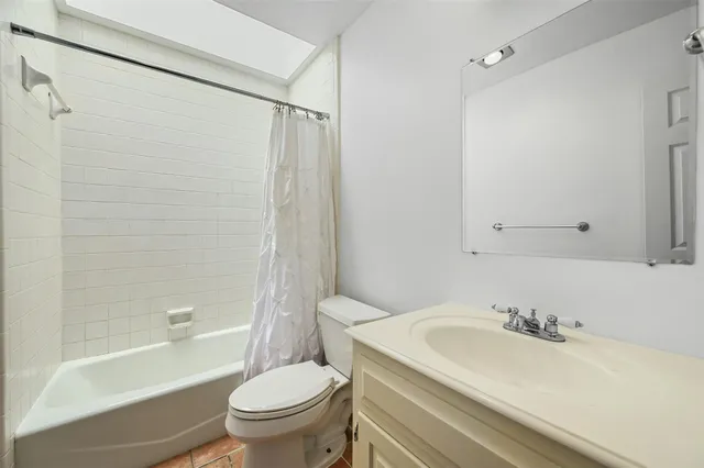 a bathroom with a granite countertop sink a toilet and a bathtub