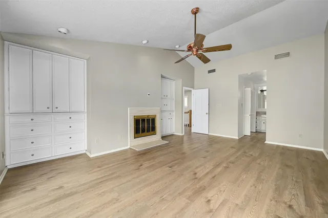 a view of empty room with wooden floor and ceiling fan