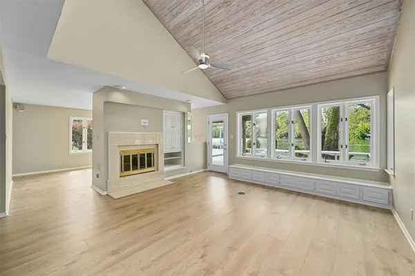 a view of an empty room with a fireplace and a window