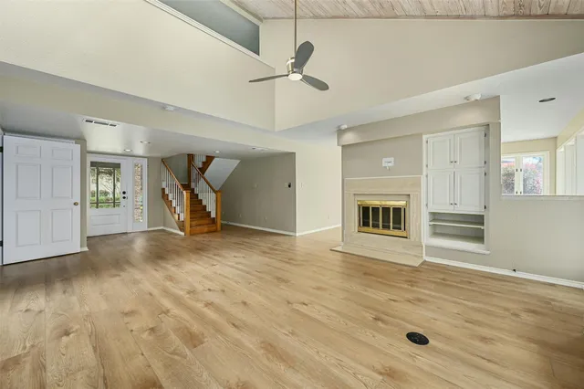 a view of a livingroom with wooden floor and a ceiling fan
