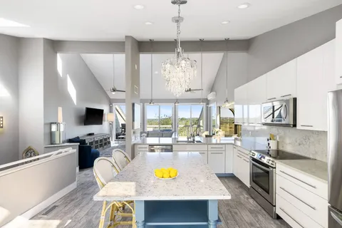 a large kitchen with a table chairs stove and cabinets