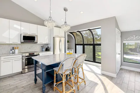 a view of a dining room with furniture a chandelier and wooden floor