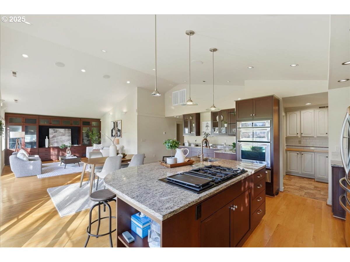 2365 Umpqua Road Woodburn, OR 97071 - Photo 11 of 33 a kitchen with a stove a refrigerator a sink a dining table and chairs with wooden floor