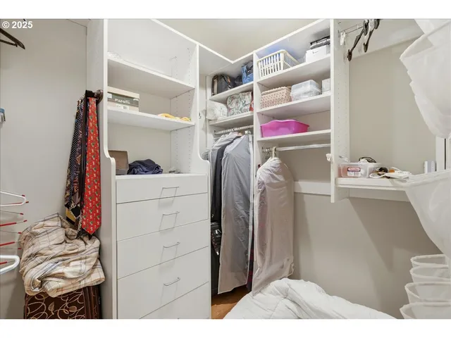 a view of walk in closet with clothes and shoes