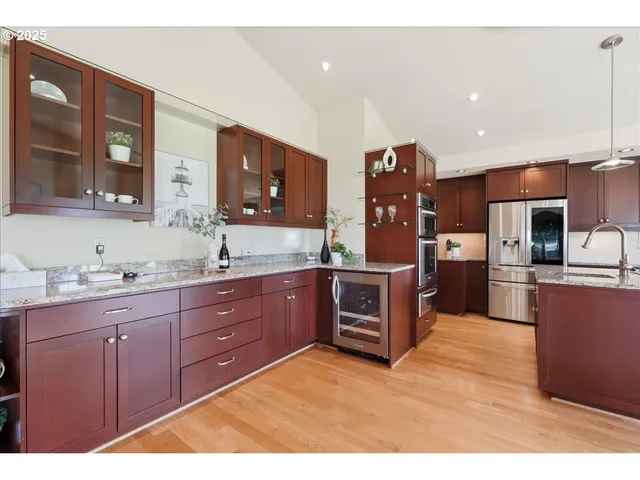a kitchen with stainless steel appliances kitchen island granite countertop a refrigerator and cabinets