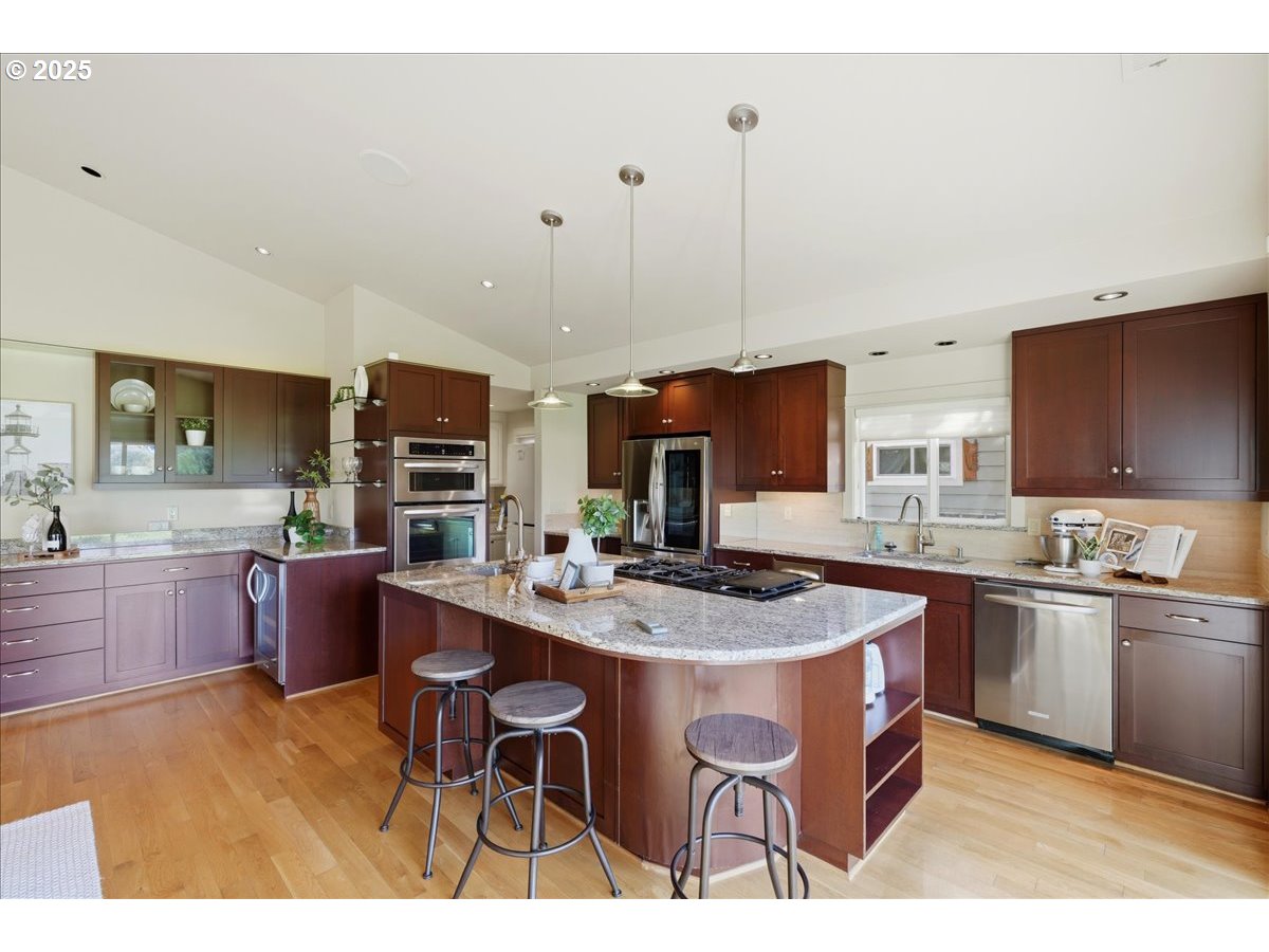 2365 Umpqua Road Woodburn, OR 97071 - Photo 10 of 33 a kitchen with stainless steel appliances granite countertop a sink a stove a dining table and chairs