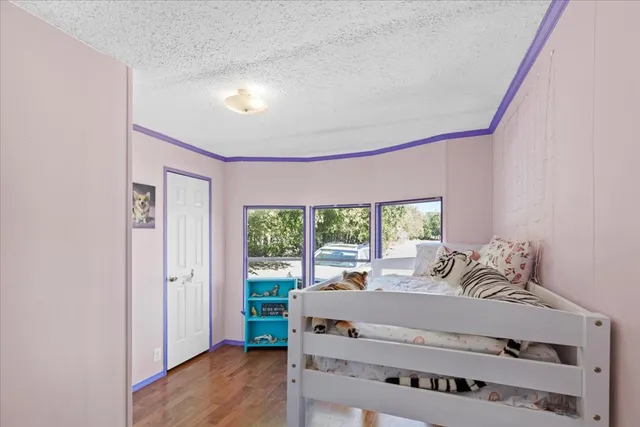 a bed sitting in a bedroom next to a window
