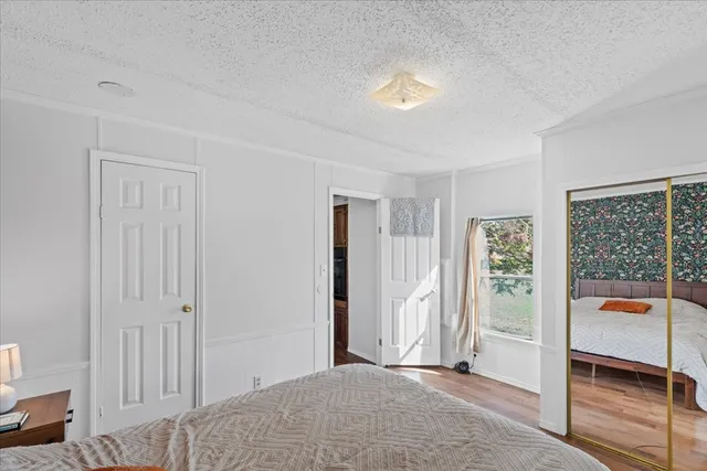 a view of a bedroom with wooden floor and windows