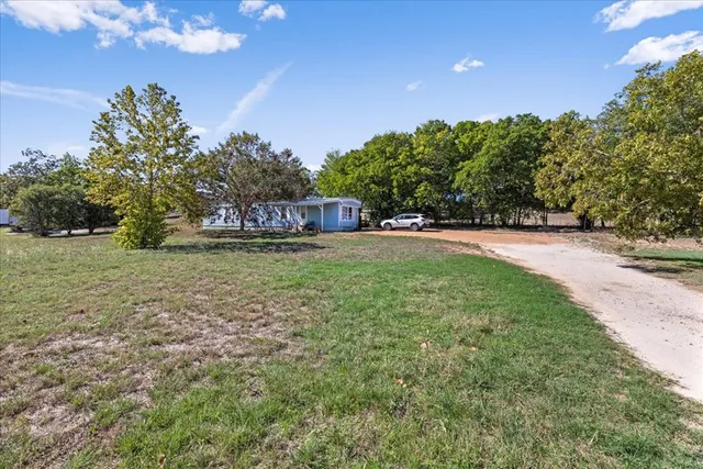 a view of a field with trees in the background