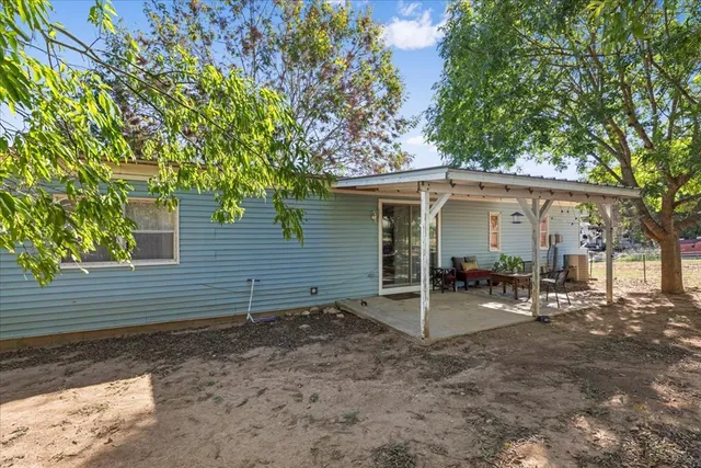 a view of a patio with table and chairs potted plants with wooden floor and fence