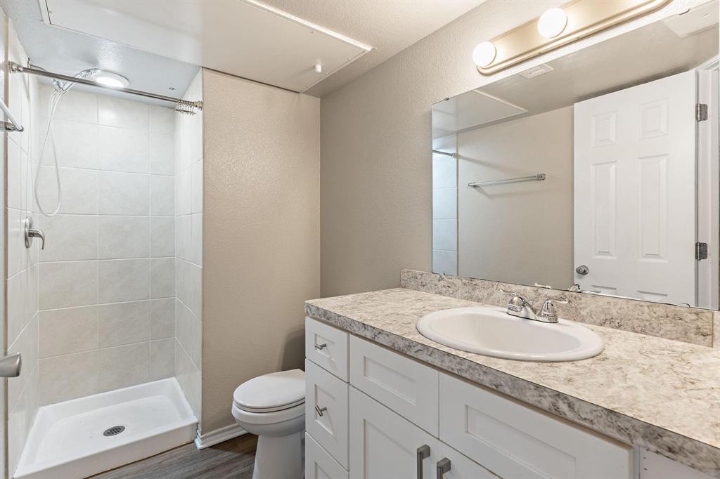 6108 Abrams Road, Unit 521 Dallas, TX 75231 - Photo 7 of 20 Bathroom featuring a white vanity with shaker-style cabinetry, a built-in sink, and a speckled countertop