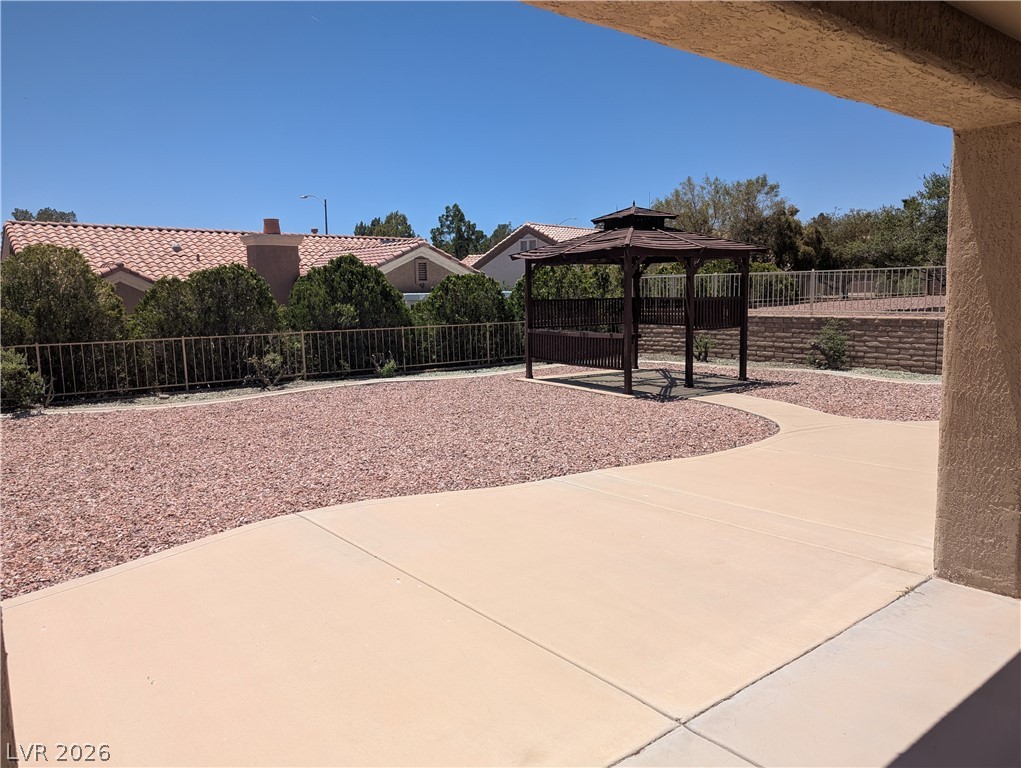 9433 Quail Ridge Drive Las Vegas, NV 89134 - Photo 22 of 23 A spacious backyard features a gazebo and low-maintenance landscaping for outdoor enjoyment.