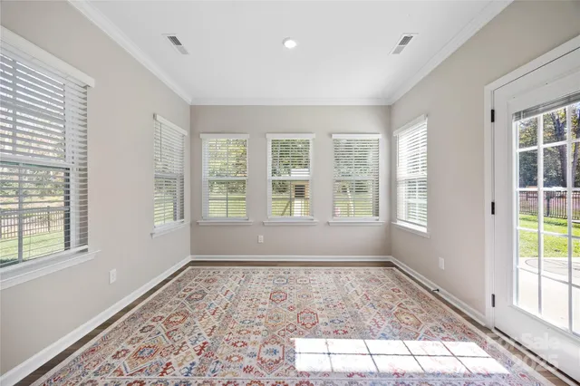 a big room with wooden floor and windows in a room