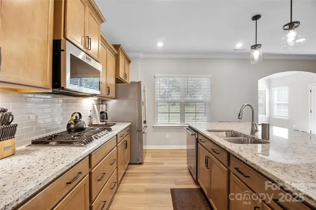 a kitchen with stainless steel appliances granite countertop a sink stove and cabinets