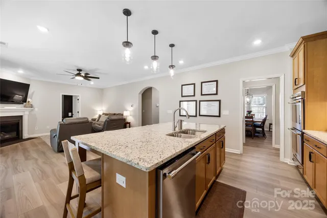 a kitchen with granite countertop kitchen island a sink table and chairs