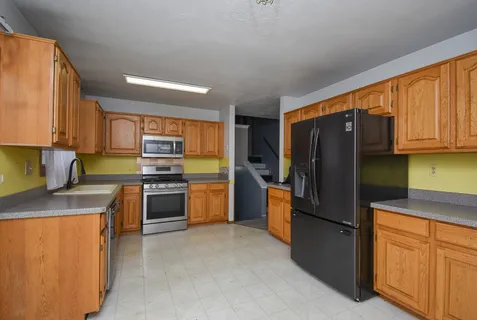 a kitchen with stainless steel appliances granite countertop a refrigerator stove and sink