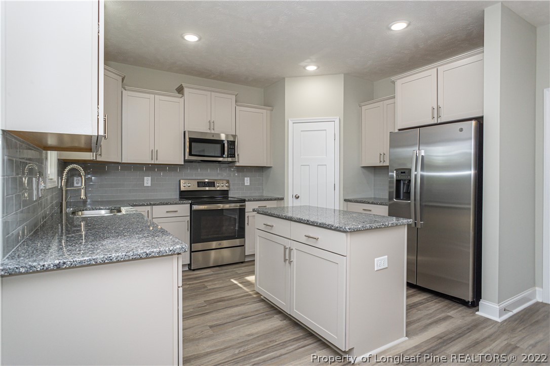 1628 Strickland Bridge Road Fayetteville, NC 28304 - Photo 12 of 34 a kitchen with stainless steel appliances granite countertop a sink stove and refrigerator