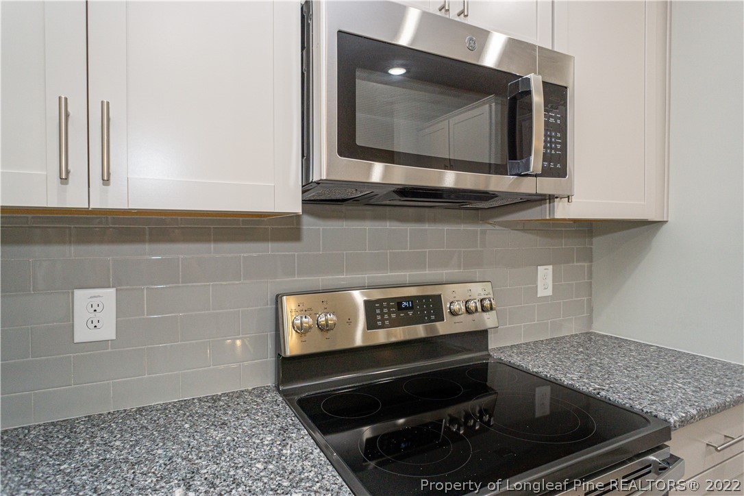 1628 Strickland Bridge Road Fayetteville, NC 28304 - Photo 14 of 34 a kitchen with a stove and a microwave