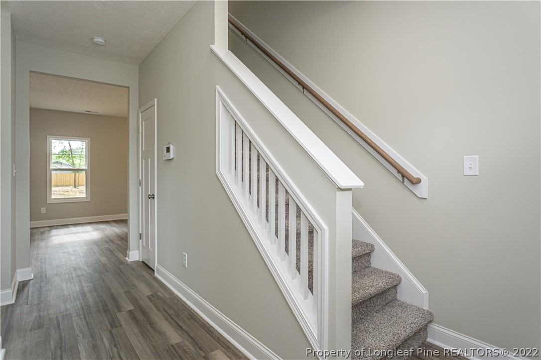1628 Strickland Bridge Road Fayetteville, NC 28304 - Photo 6 of 34 a view of staircase with wooden floor and white walls