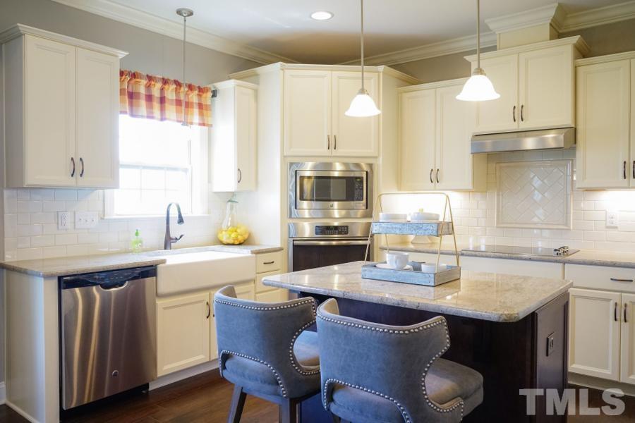 7709 Stonehenge Farm Lane Raleigh, NC 27613 - Photo 2 of 24 a kitchen with granite countertop a sink a stove and chairs