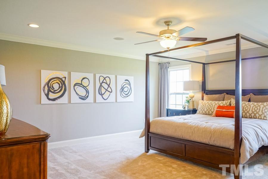 7709 Stonehenge Farm Lane Raleigh, NC 27613 - Photo 15 of 24 a bedroom with a bed and a chandelier