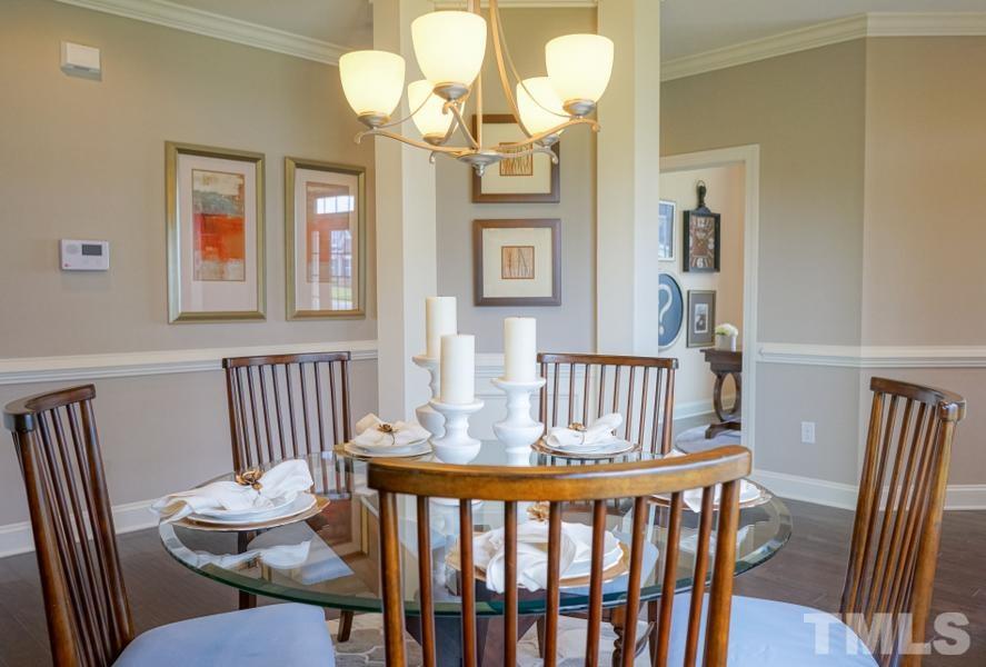 7709 Stonehenge Farm Lane Raleigh, NC 27613 - Photo 17 of 24 a view of a dining room with furniture wooden floor and chandelier
