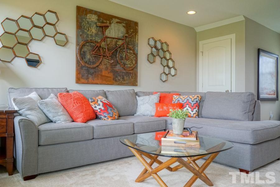7709 Stonehenge Farm Lane Raleigh, NC 27613 - Photo 21 of 24 a living room with a couch and a dining table with painted walls