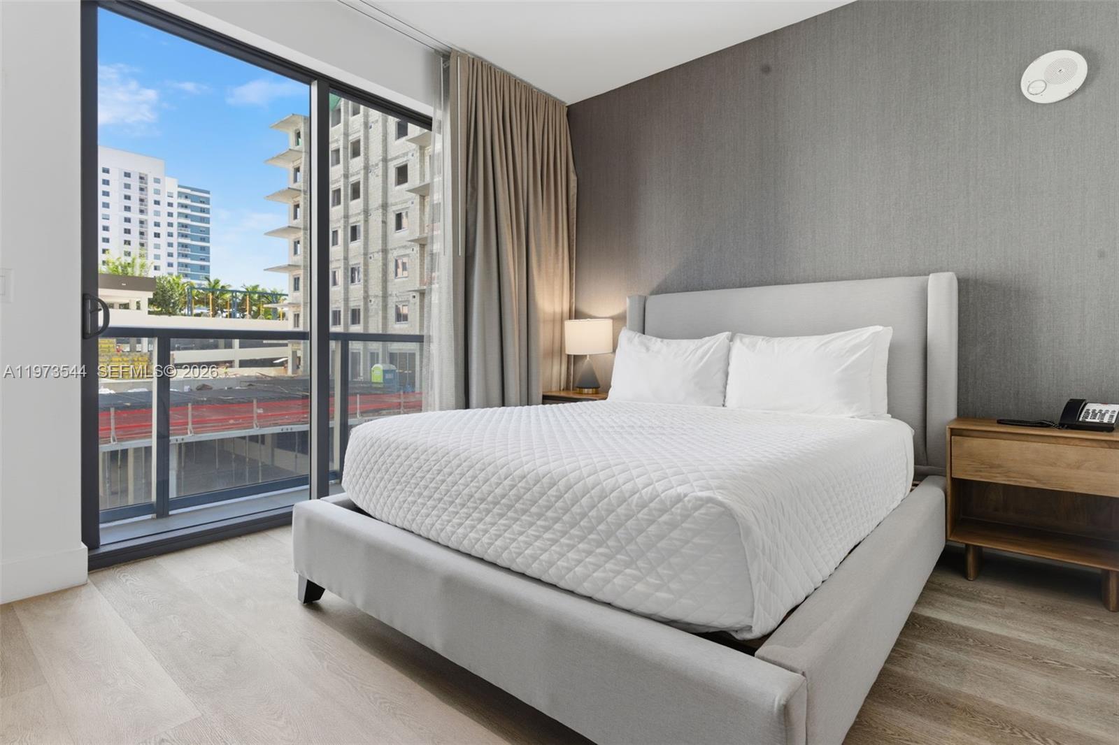 229 Southwest 9th Street, Unit 407 Miami, FL 33130 - Photo 23 of 29 a spacious bedroom with a bed and glass door