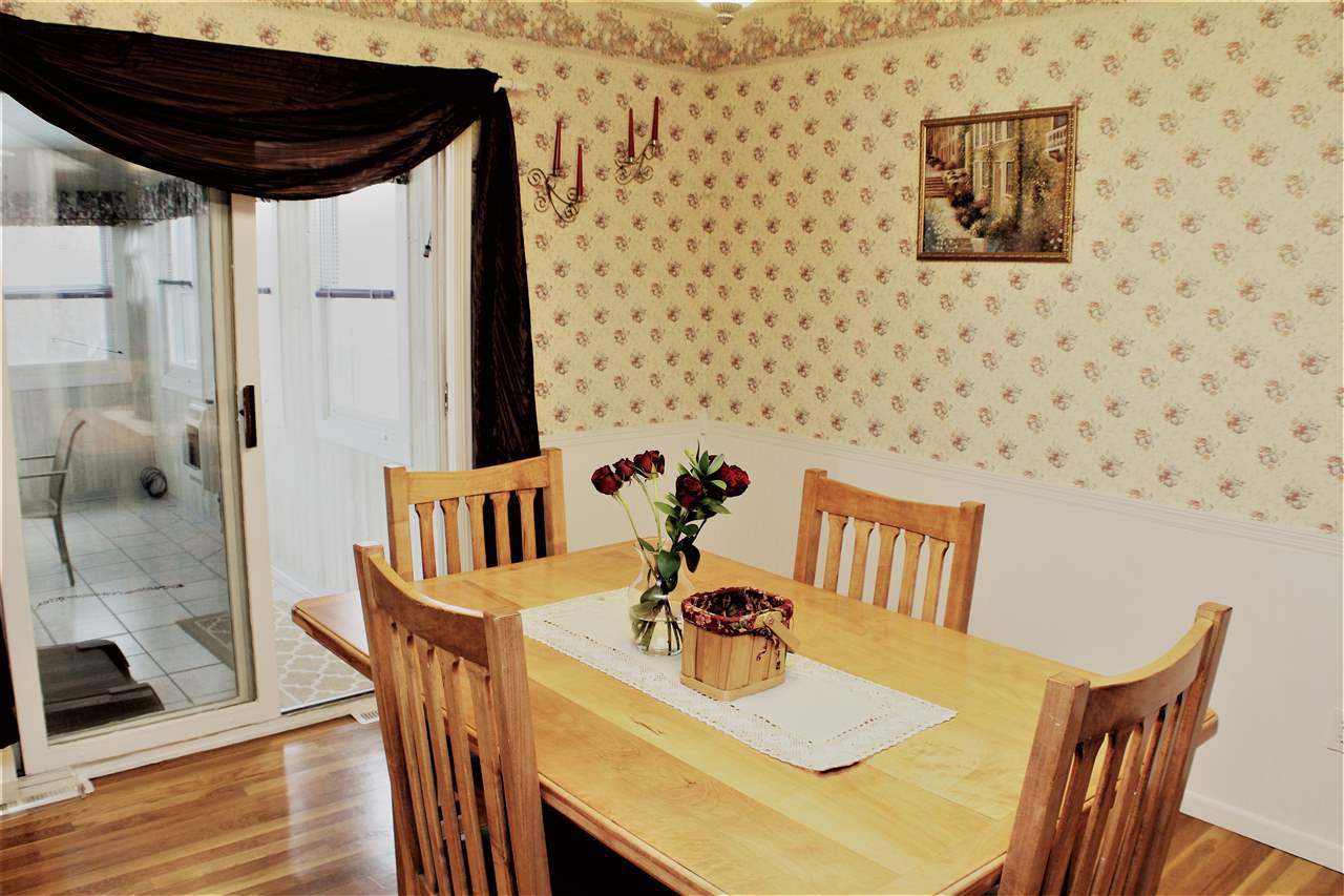 10619 Grover Oaks Road Roscoe, IL 61073 - Photo 11 of 24 a view of a dining room with furniture and wooden floor