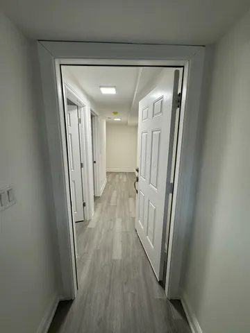 a view of a hallway with wooden floor and staircase