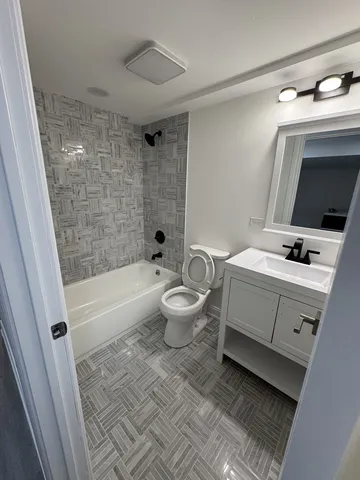 a bathroom with a bathtub sink mirror and toilet