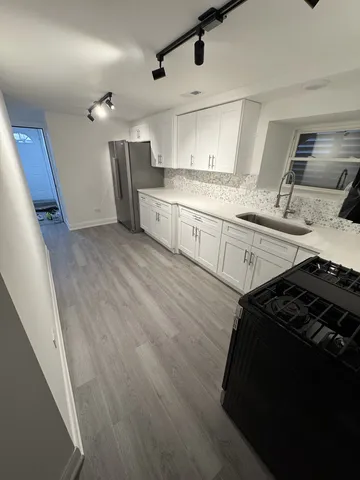 a kitchen with granite countertop a stove and cabinets