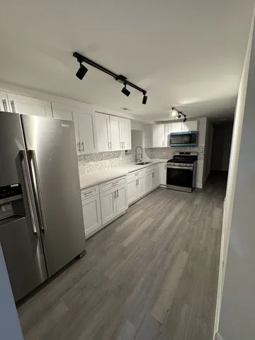 a kitchen with stainless steel appliances a refrigerator sink and stove