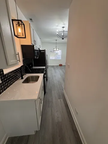 a kitchen with a sink and wooden floor