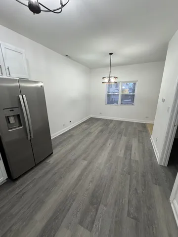 a view of a refrigerator in kitchen and wooden floor