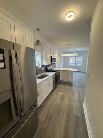 a kitchen with granite countertop a refrigerator and a stove top oven