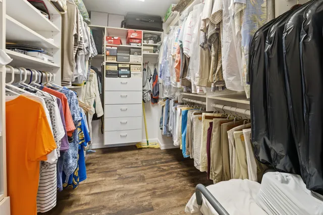 a view of walk in closet with clothes and shoes
