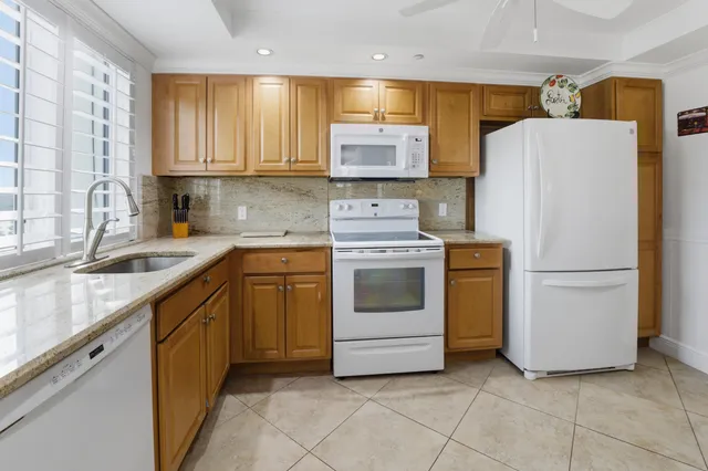 a kitchen with a white stove refrigerator and cabinets