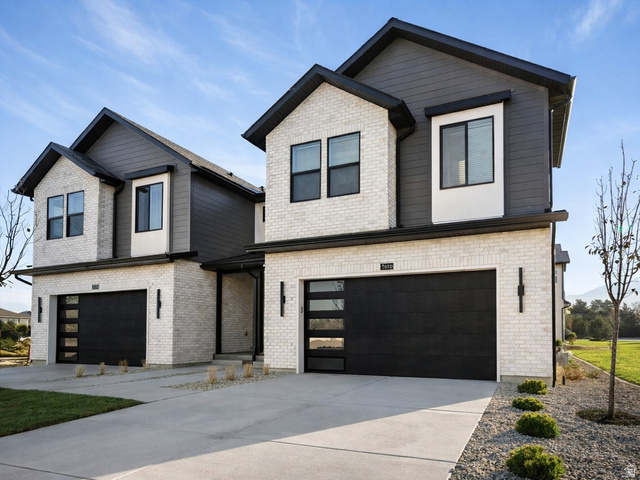 6715 South Vaughn Lane, Unit 8 Midvale, UT 84047 - Photo 1 of 1 View of front of property featuring an attached garage, concrete driveway, and brick siding