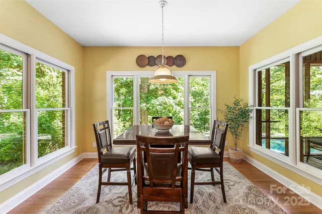 a dining room with furniture a chandelier and wooden floor