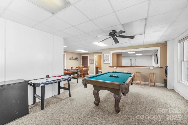 a room with furniture pool table and ceiling fan