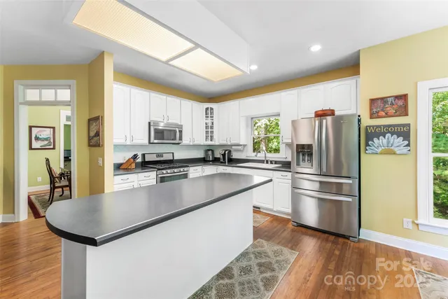 a kitchen with granite countertop stainless steel appliances a refrigerator microwave and stove