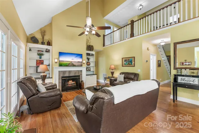 a living room with furniture a fireplace and a ceiling fan