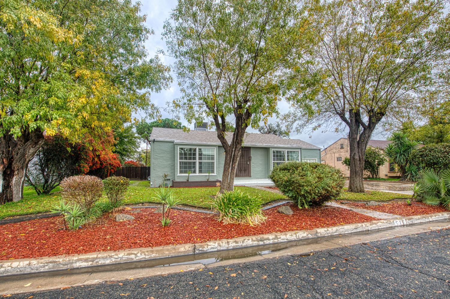 a front view of a house with a yard and a garden