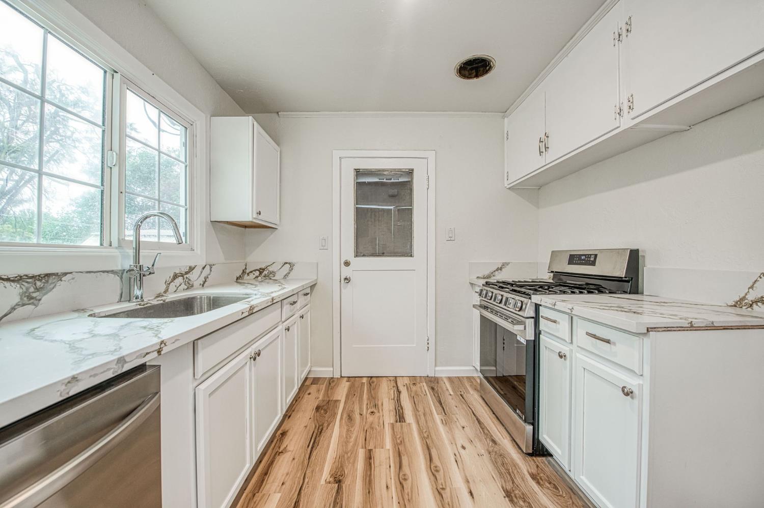 517 Rotan Avenue Madera, CA 93637 - Photo 11 of 32 a kitchen with a sink stove and cabinets