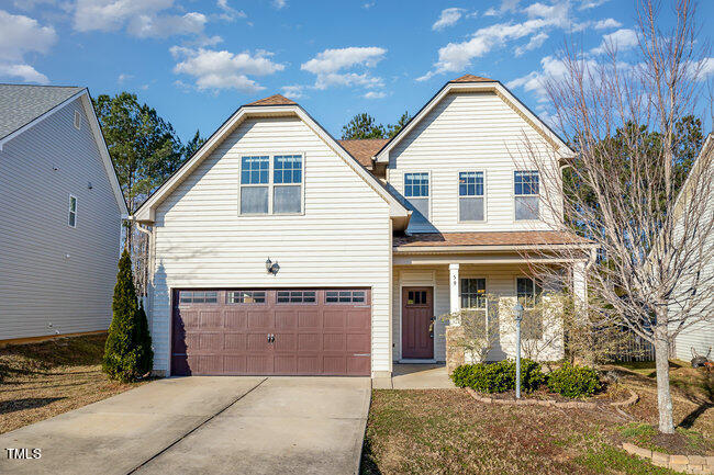 a view of a white house with large windows and a small yard