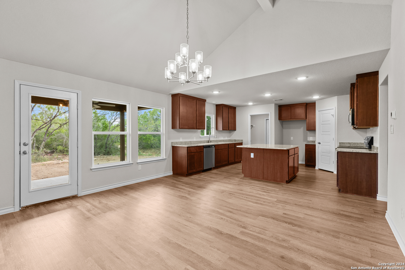 117 Sylas Hayes Loop Pleasanton, TX 78064 - Photo 13 of 38 a large kitchen with stainless steel appliances granite countertop a large counter top a chandelier and a view of kitchen