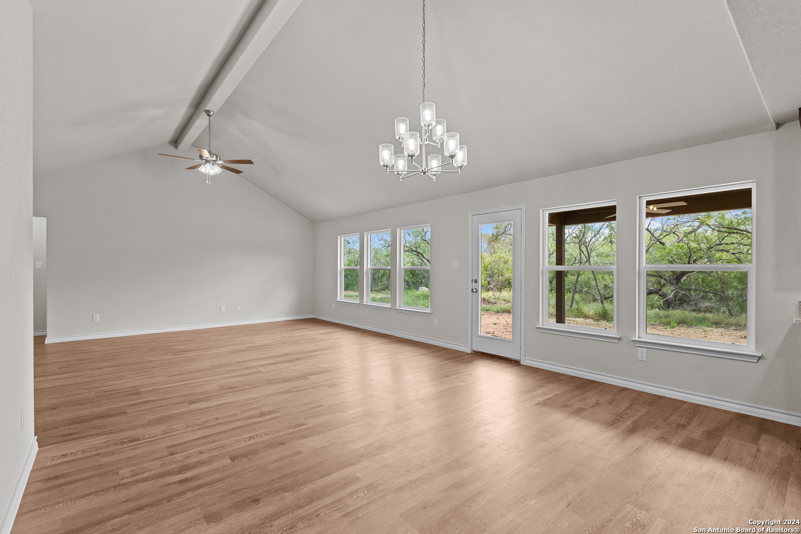 117 Sylas Hayes Loop Pleasanton, TX 78064 - Photo 17 of 38 a view of an empty room with wooden floor and a window