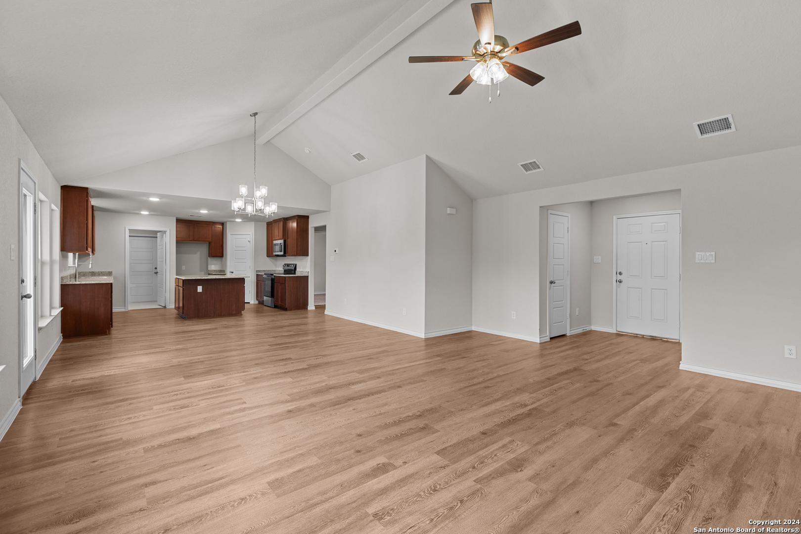 117 Sylas Hayes Loop Pleasanton, TX 78064 - Photo 9 of 38 a view of a livingroom with a flat screen tv wooden floor and a ceiling fan