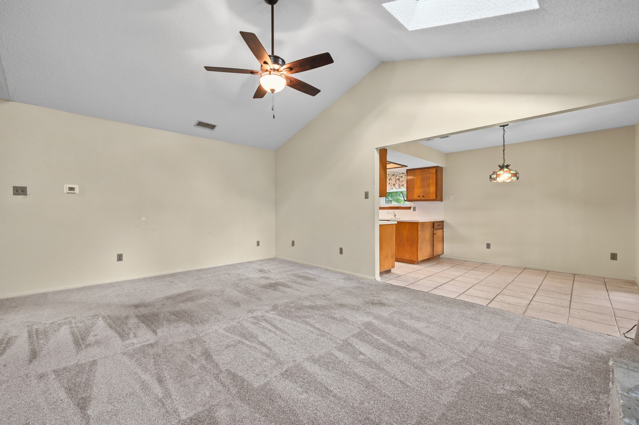 10504 Hard Rock Road Austin, TX 78750 - Photo 9 of 28 A spacious living area with vaulted ceilings seamlessly connects to a compact kitchen.